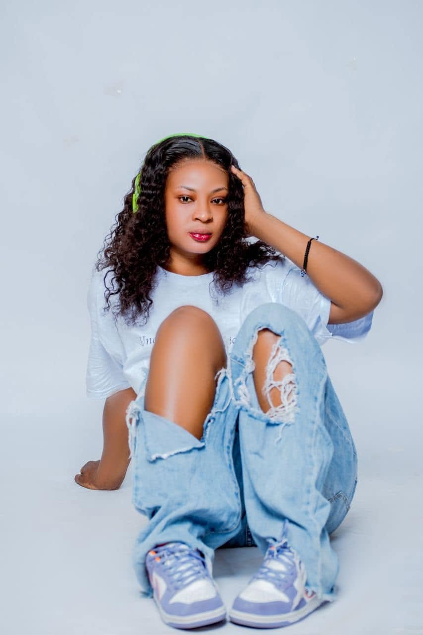 Saint Chicago seated in ripped jeans and a white top